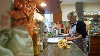  Ev hanımı evlerinin mutfağında patates soyup kesiyor. Yüksek kalite 4k görüntü