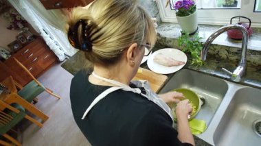  Ev hanımı evlerinin mutfağında patates soyup kesiyor. Yüksek kalite 4k görüntü