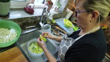 Ev hanımı mutfağında marul yıkıyor. Yüksek kalite 4k görüntü