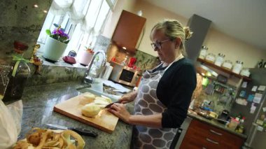  Ev hanımı evlerinin mutfağında patates soyup kesiyor. Yüksek kalite 4k görüntü