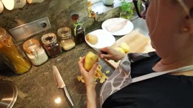  Ev hanımı evlerinin mutfağında patates soyup kesiyor. Yüksek kalite 4k görüntü