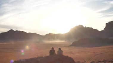 Wadi Rum çölünde gün batımını izleyen çiftin zamanı. Yüksek kaliteli FullHD görüntüler