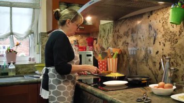 Ev hanımı ev mutfağında geleneksel İspanyol omleti pişiriyor. Yüksek kalite 4k görüntü.