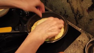 Ev hanımı ev mutfağında geleneksel İspanyol omleti pişiriyor. Yüksek kalite 4k görüntü.