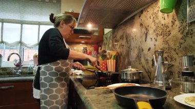 Ev hanımı ev mutfağında geleneksel İspanyol omleti pişiriyor. Yüksek kalite 4k görüntü.