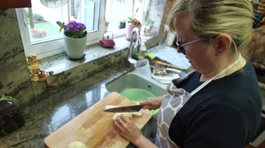  Ev hanımı evlerinin mutfağında patates soyup kesiyor. Yüksek kalite 4k görüntü