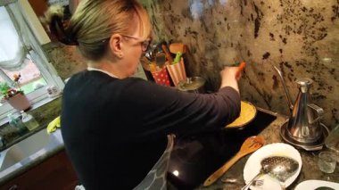 Ev hanımı ev mutfağında geleneksel İspanyol omleti pişiriyor. Yüksek kalite 4k görüntü.