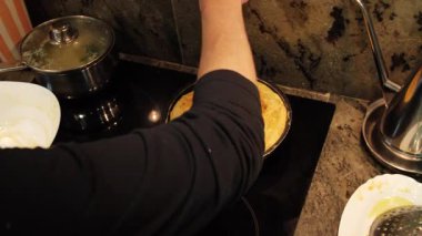 Ev hanımı ev mutfağında geleneksel İspanyol omleti pişiriyor. Yüksek kalite 4k görüntü.