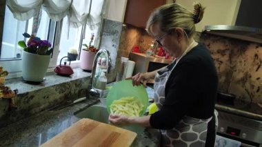  Ev hanımı evlerinin mutfağında patates soyup kesiyor. Yüksek kalite 4k görüntü