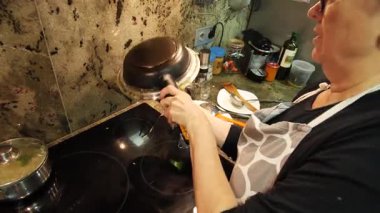 Ev hanımı ev mutfağında geleneksel İspanyol omleti pişiriyor. Yüksek kalite 4k görüntü.