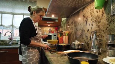 Ev hanımı ev mutfağında geleneksel İspanyol omleti pişiriyor. Yüksek kalite 4k görüntü.