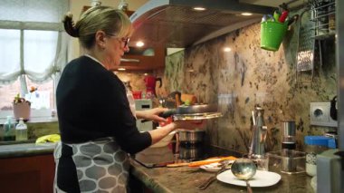 Ev hanımı ev mutfağında geleneksel İspanyol omleti pişiriyor. Yüksek kalite 4k görüntü.