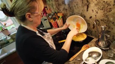 Ev hanımı ev mutfağında geleneksel İspanyol omleti pişiriyor. Yüksek kalite 4k görüntü.