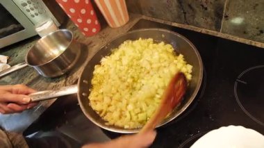 Ev hanımı ev mutfağında geleneksel İspanyol omleti pişiriyor. Yüksek kalite 4k görüntü.