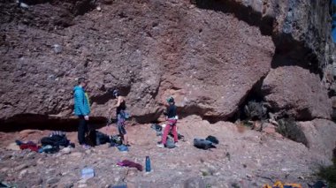 Arkadaşlar doğada kırmızı kayalara tırmanıyor. Yüksek kalite 4k görüntü