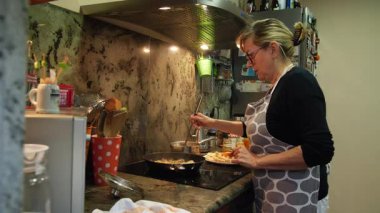 Ev hanımı evde balık güveci pişiriyor. Yüksek kalite 4k görüntü