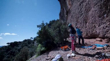 Arkadaşlar doğada kırmızı kayalara tırmanıyor. Yüksek kalite 4k görüntü