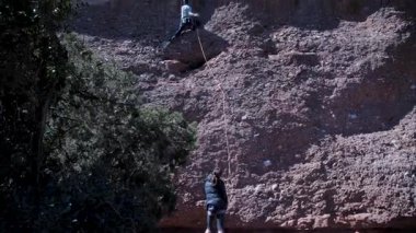 Arkadaşlar doğada kırmızı kayalara tırmanıyor. Yüksek kalite 4k görüntü