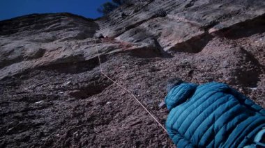 Arkadaşlar doğada kırmızı kayalara tırmanıyor. Yüksek kalite 4k görüntü