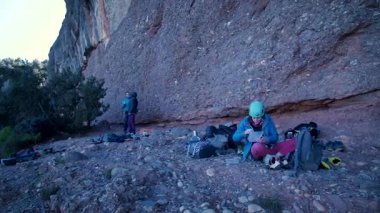 Arkadaşlar doğada kırmızı kayalara tırmanıyor. Yüksek kalite 4k görüntü
