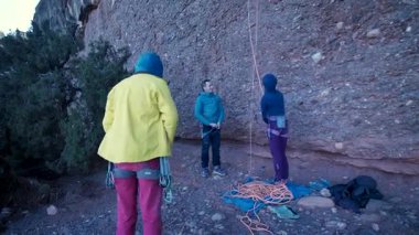 Arkadaşlar doğada kırmızı kayalara tırmanıyor. Yüksek kalite 4k görüntü