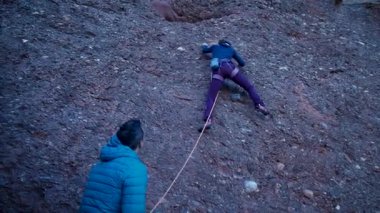 Arkadaşlar doğada kırmızı kayalara tırmanıyor. Yüksek kalite 4k görüntü