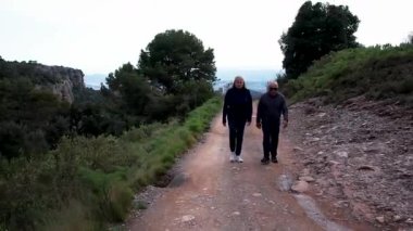 Barcelona yakınlarındaki dağlarda yürüyüş yapan yaşlı çift. Yüksek kalite 4k drone görüntüsü
