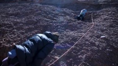 Arkadaşlar doğada kırmızı kayalara tırmanıyor. Yüksek kalite 4k görüntü