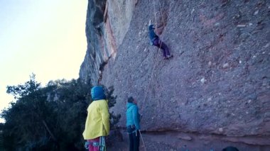 Arkadaşlar doğada kırmızı kayalara tırmanıyor. Yüksek kalite 4k görüntü