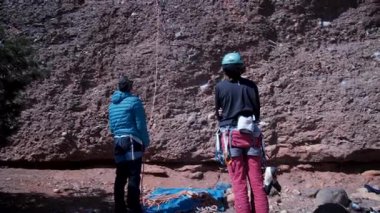 Arkadaşlar doğada kırmızı kayalara tırmanıyor. Yüksek kalite 4k görüntü
