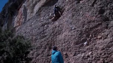 Arkadaşlar doğada kırmızı kayalara tırmanıyor. Yüksek kalite 4k görüntü