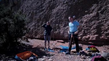 Arkadaşlar doğada kırmızı kayalara tırmanıyor. Yüksek kalite 4k görüntü