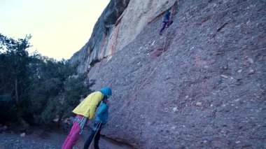 Arkadaşlar doğada kırmızı kayalara tırmanıyor. Yüksek kalite 4k görüntü