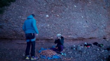 Arkadaşlar doğada kırmızı kayalara tırmanıyor. Yüksek kalite 4k görüntü
