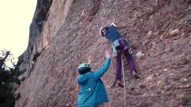 Dişi arkadaşlar gerçek kayaya tırmanıyorlar. Yüksek kalite 4k görüntü