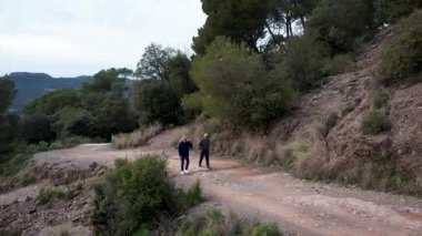 Barcelona yakınlarındaki dağlarda yürüyüş yapan yaşlı çift. Yüksek kalite 4k drone görüntüsü