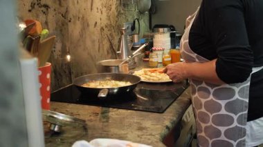 Ev hanımı evde balık güveci pişiriyor. Yüksek kalite 4k görüntü