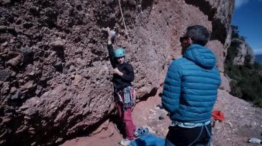 Arkadaşlar doğada kırmızı kayalara tırmanıyor. Yüksek kalite 4k görüntü