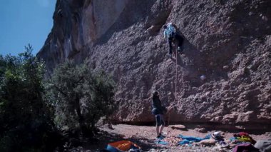 Arkadaşlar doğada kırmızı kayalara tırmanıyor. Yüksek kalite 4k görüntü
