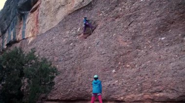 Dişi arkadaşlar gerçek kayaya tırmanıyorlar. Yüksek kalite 4k görüntü