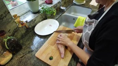 Ev hanımı evde balık güveci pişiriyor. Yüksek kalite 4k görüntü