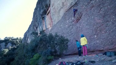 Arkadaşlar doğada kırmızı kayalara tırmanıyor. Yüksek kalite 4k görüntü