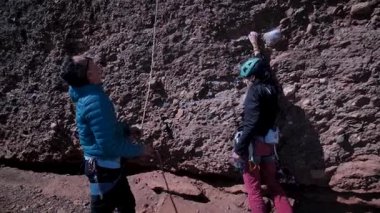Arkadaşlar doğada kırmızı kayalara tırmanıyor. Yüksek kalite 4k görüntü