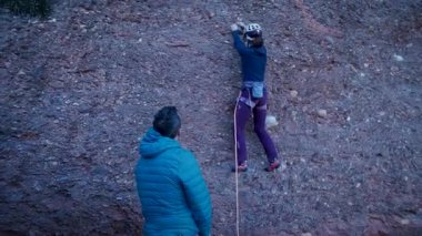 Arkadaşlar doğada kırmızı kayalara tırmanıyor. Yüksek kalite 4k görüntü
