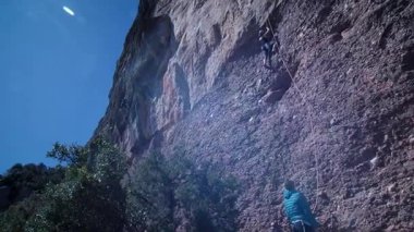 Arkadaşlar doğada kırmızı kayalara tırmanıyor. Yüksek kalite 4k görüntü