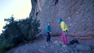 Arkadaşlar doğada kırmızı kayalara tırmanıyor. Yüksek kalite 4k görüntü