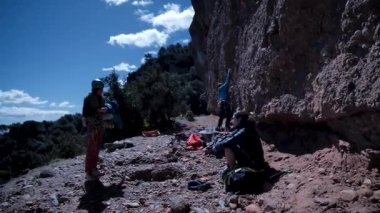 Arkadaşlar doğada kırmızı kayalara tırmanıyor. Yüksek kalite 4k görüntü