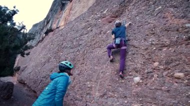 Dişi arkadaşlar gerçek kayaya tırmanıyorlar. Yüksek kalite 4k görüntü