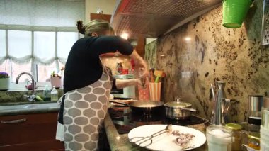 Ev hanımı evde balık güveci pişiriyor. Yüksek kalite 4k görüntü