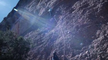 Arkadaşlar doğada kırmızı kayalara tırmanıyor. Yüksek kalite 4k görüntü